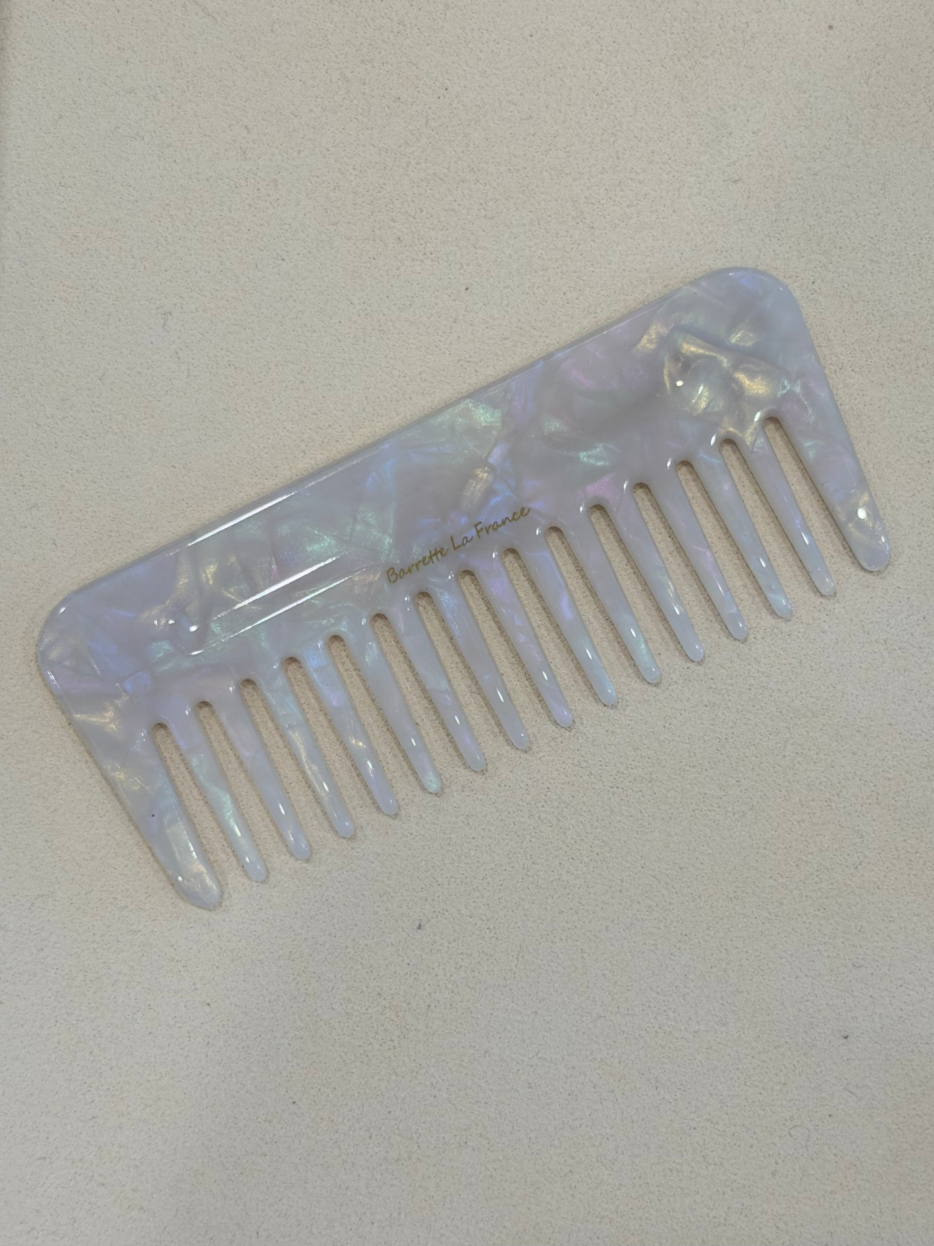Iridescent comb on a beige background