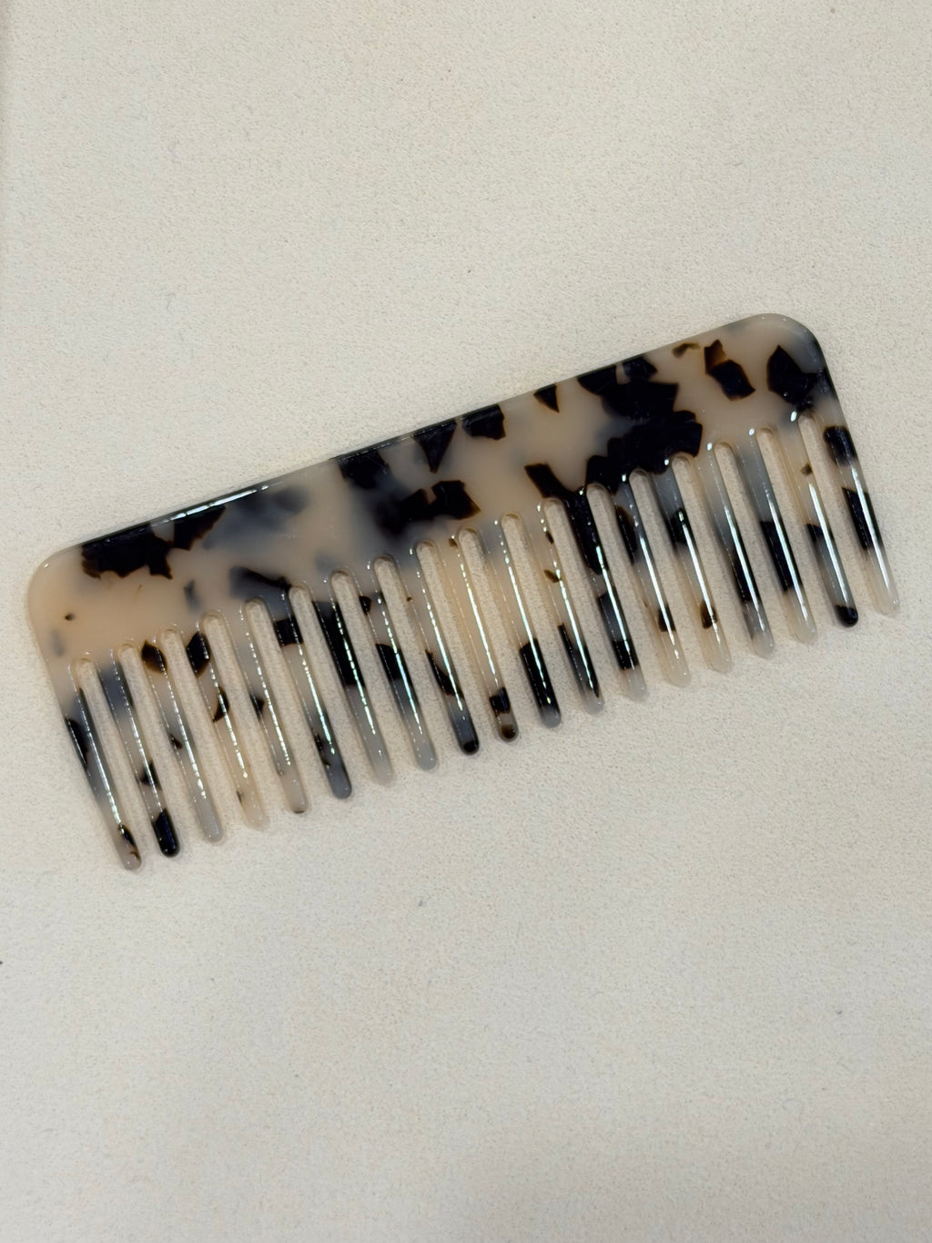 Tortoiseshell patterned comb on a beige background