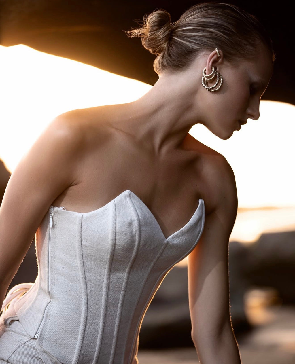 Cream sculpted corset from Solana, shown in a close-up sunset shot highlighting the structured paneling and sweetheart neckline.
