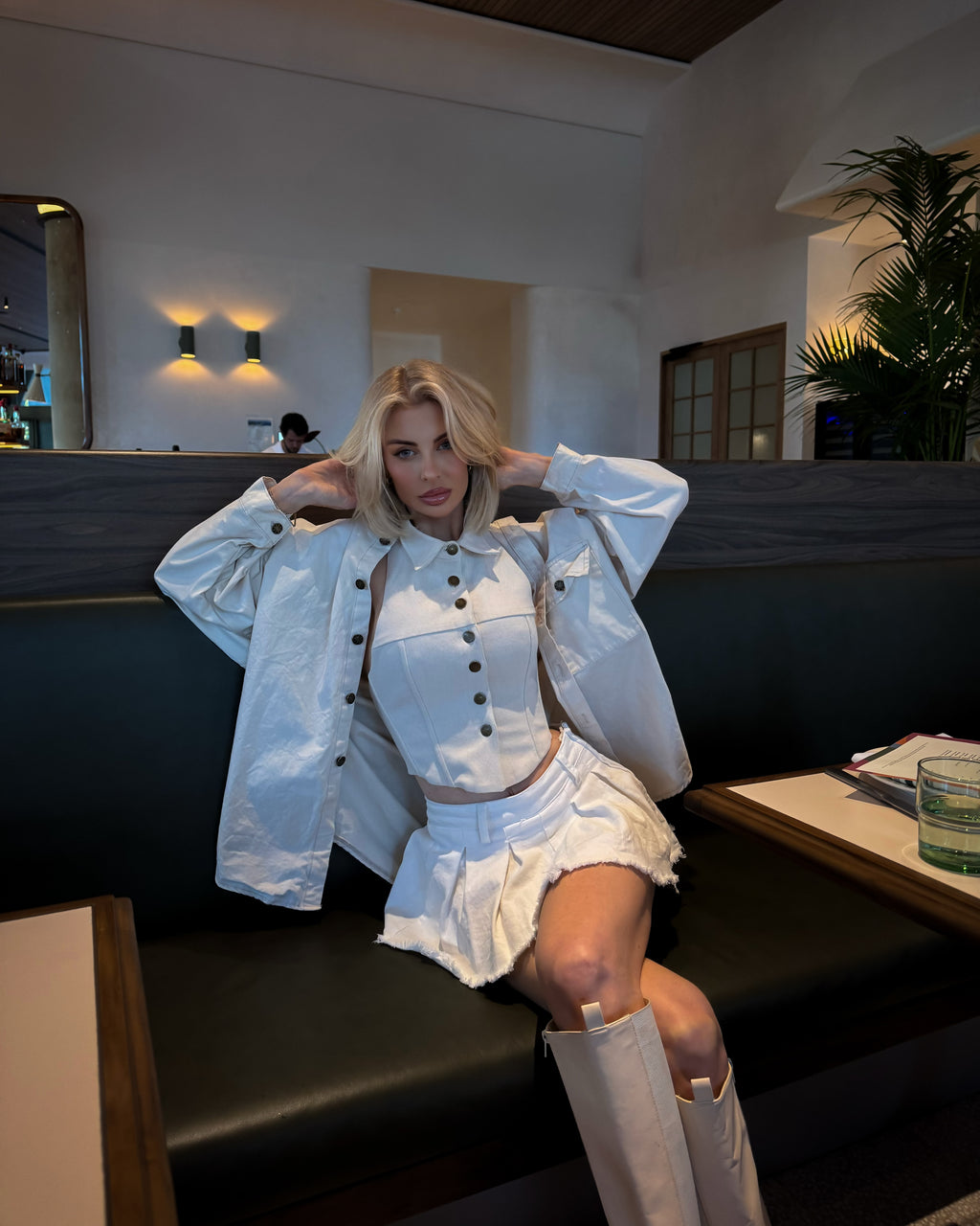 Ivory structured vest corset with panel detailing and brass buttons displayed inside Solana boutique.